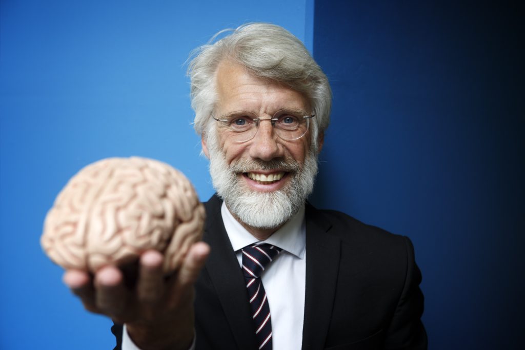 Neuropsycholoog Erik Scherder houdt een model van een brein omhoog